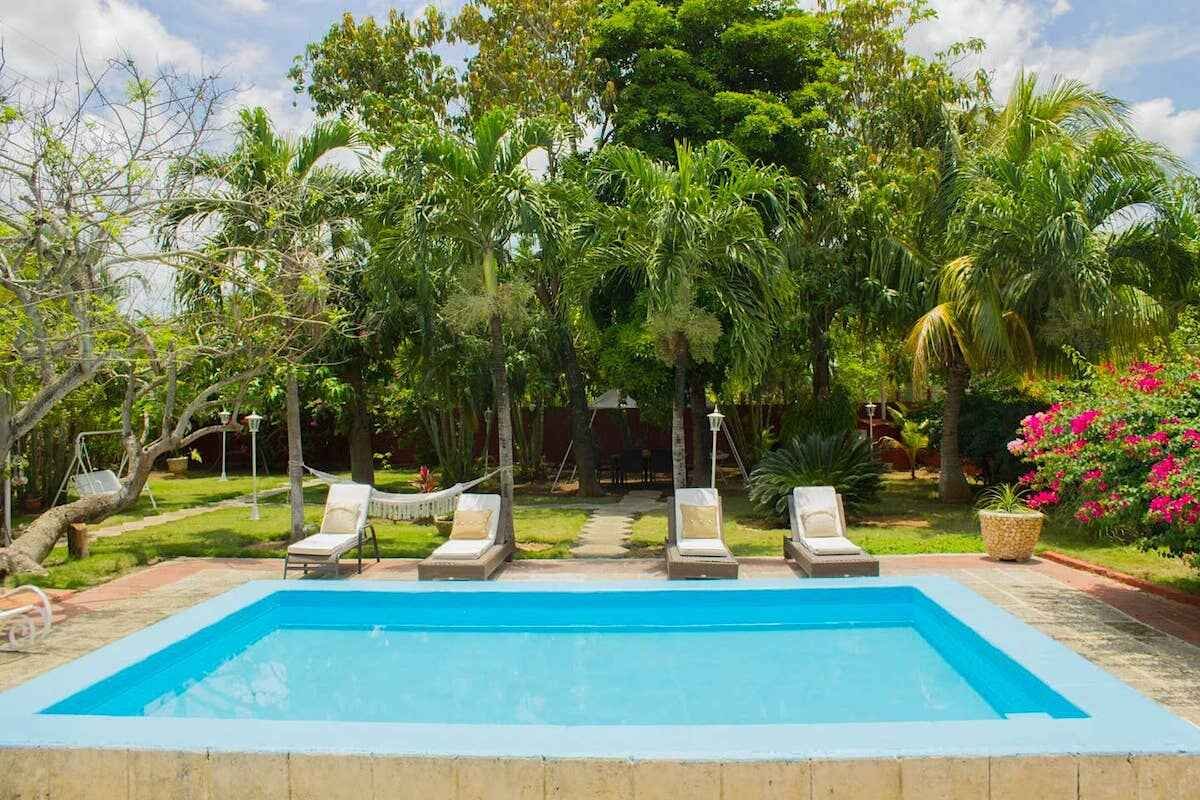 Garden pool and shaded terrace at Villa Maison in Santa Fe, Havana