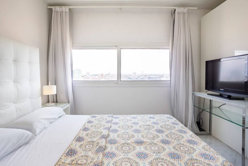 Bedroom with wide city-facing window at Penthouse Atlantic City