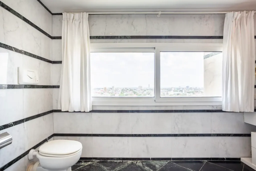 Ensuite bathroom with city-facing window at Penthouse Atlantic City