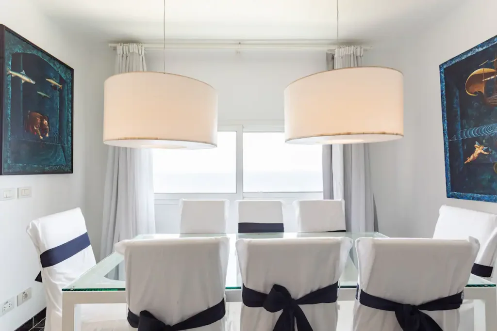 Sea-facing dining room with white chairs in the private penthouse