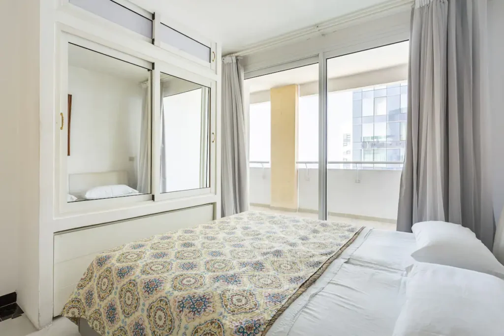Penthouse bedroom opening toward a bright glazed exterior
