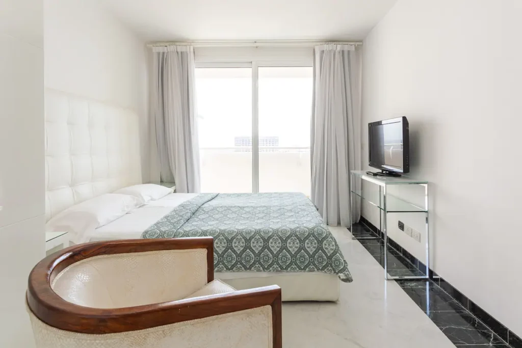 Spacious bedroom with seating and large windows in Vedado