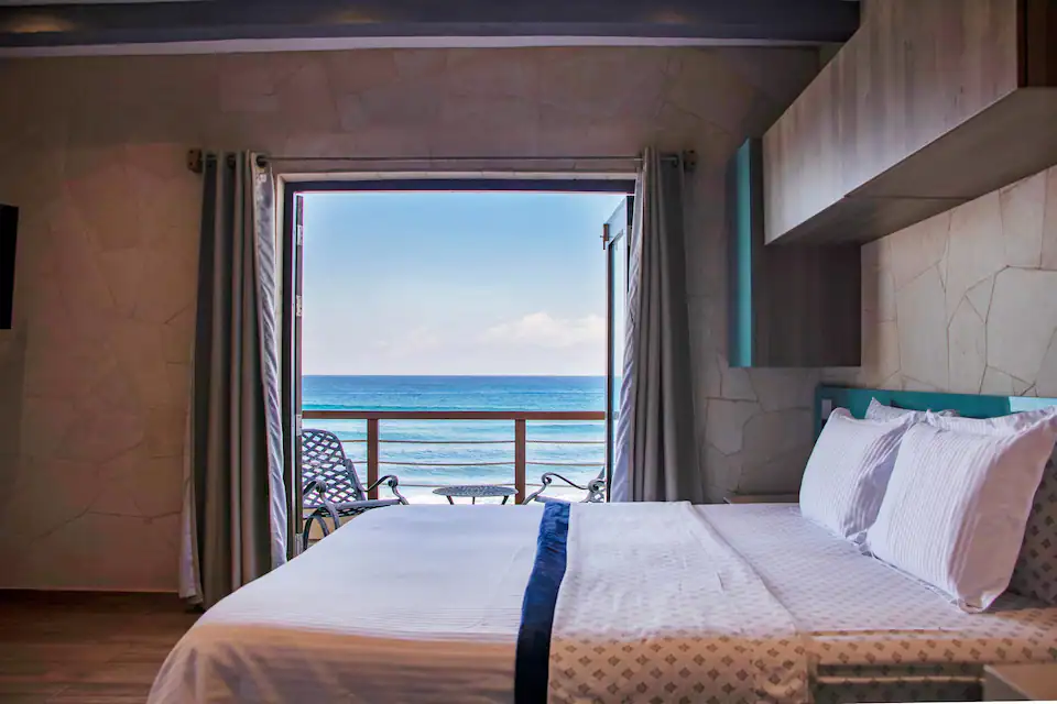 Bedroom opening onto a sea-facing balcony in Havana