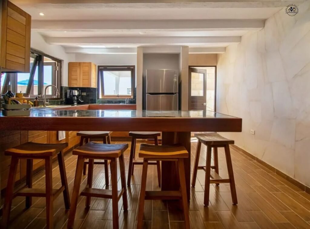 Timber kitchen island and dining stools in the oceanfront residence