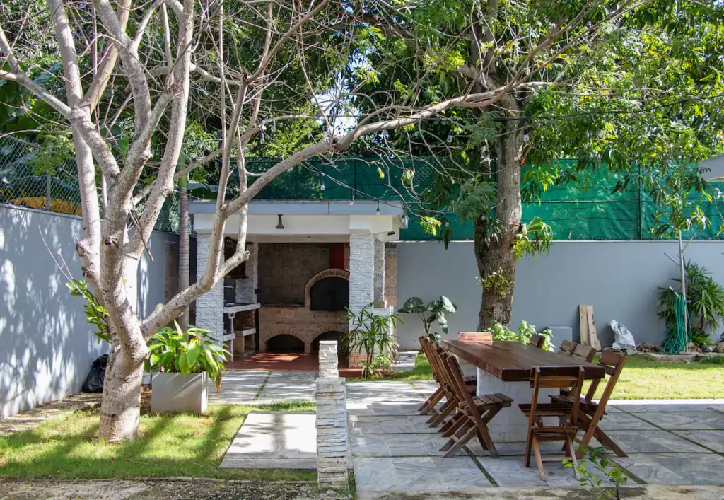 Garden dining table beneath trees at Villa Aurora