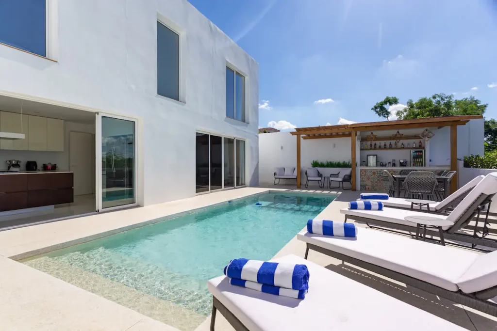 Heated pool courtyard with loungers at Villa Bella