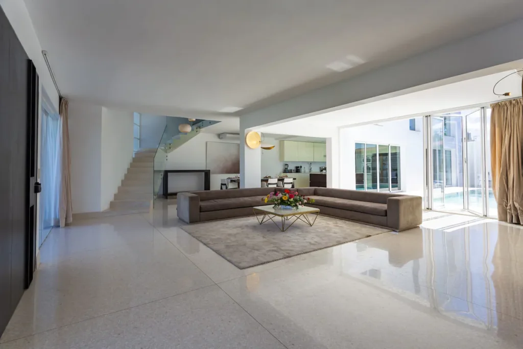Open-plan living room with pool access at Villa Bella