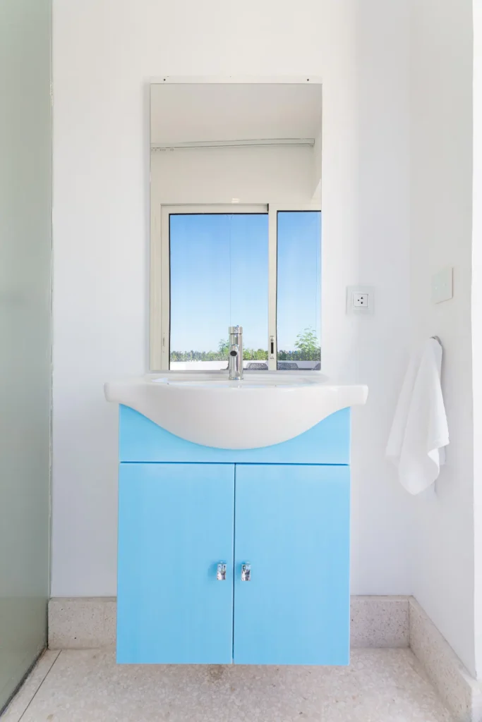 Bright bathroom with sculpted blue vanity at Villa Bella