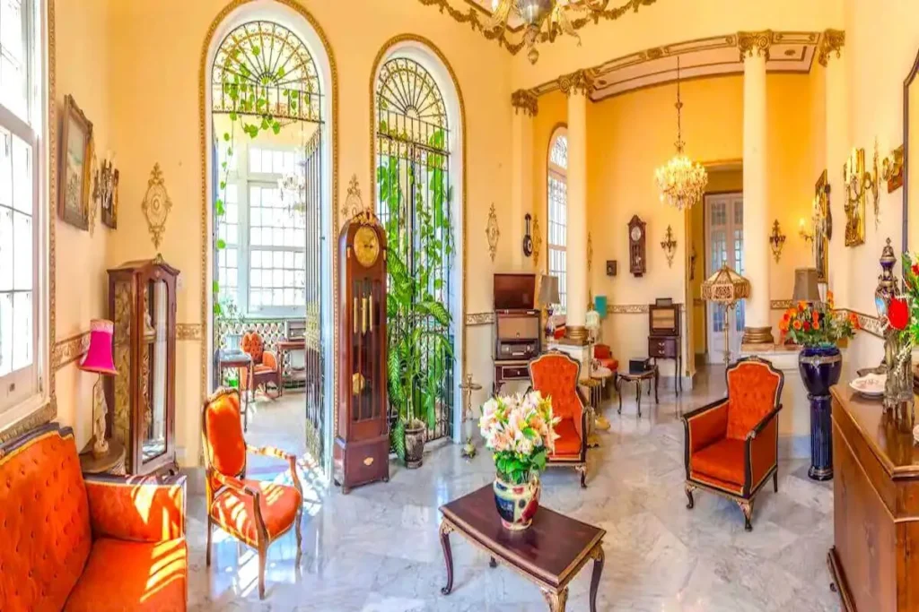 Formal salon with red seating inside Villa Condesa