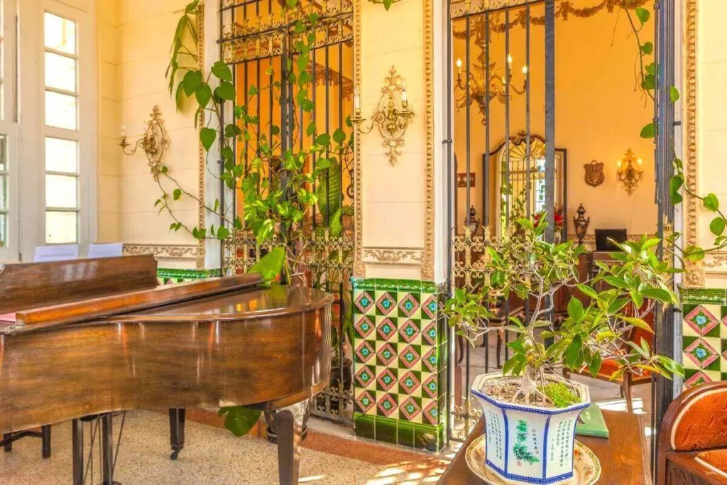 Piano beside a planted interior veranda at Villa Condesa
