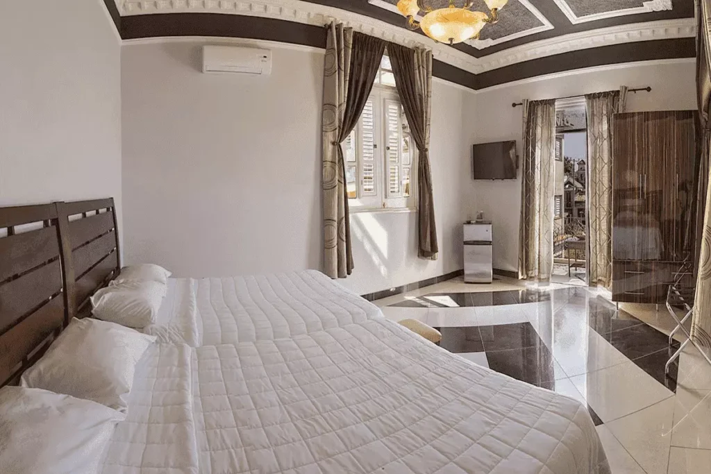 Bright double bedroom with balcony doors at Villa Costa