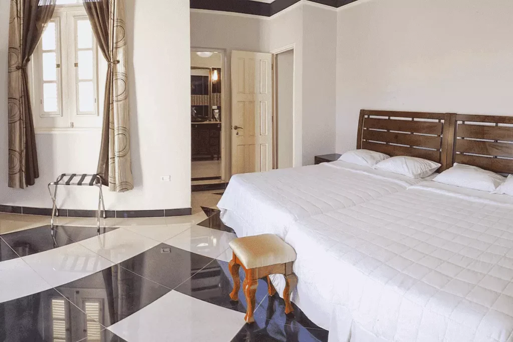 Double bedroom with dark timber bed at Villa Costa
