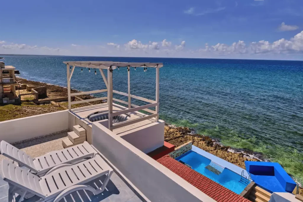 White rooftop seating facing the ocean at Villa Isis