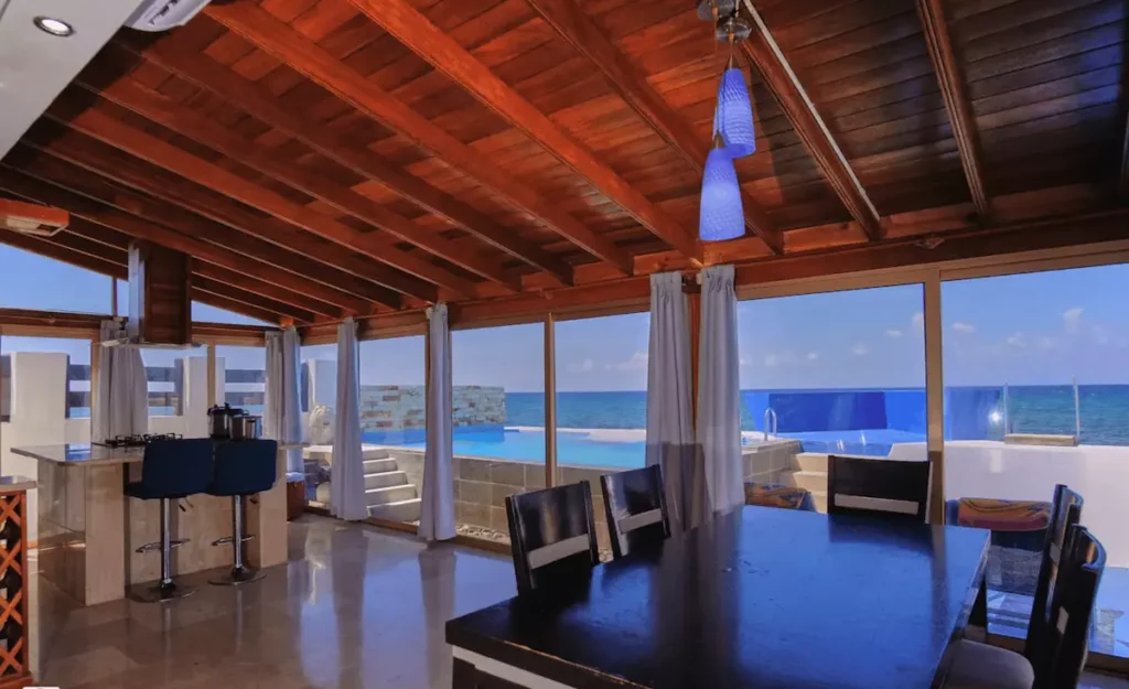 Covered outdoor dining terrace overlooking the sea at Villa Isis