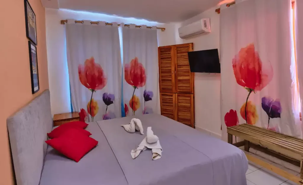 Bright bedroom with red floral artwork at Villa Isis