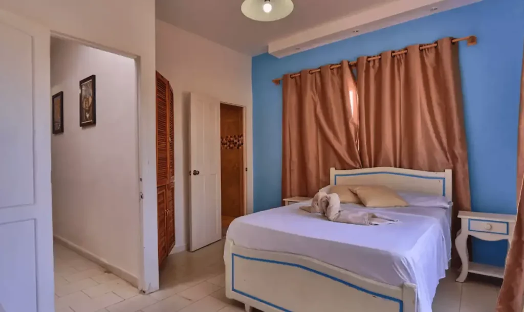 Pastel bedroom with double bed inside Villa Isis