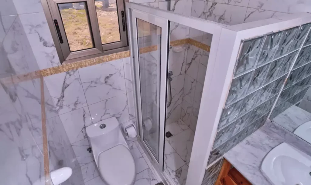 Bathroom with shower and glass-block window at Villa Isis