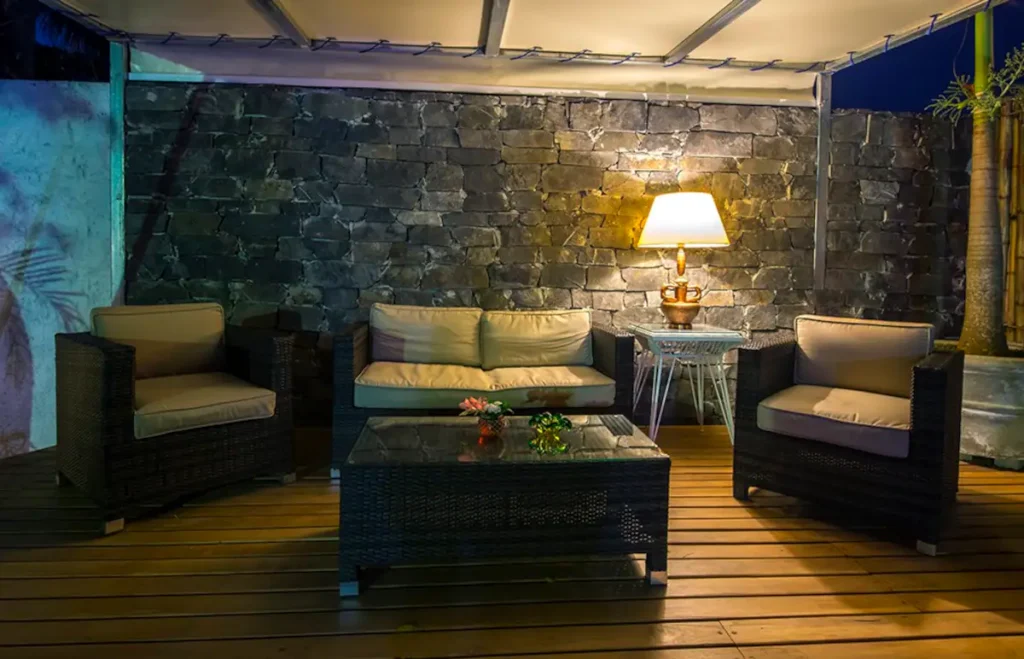 Covered outdoor lounge with stone wall at Villa Las Cañas