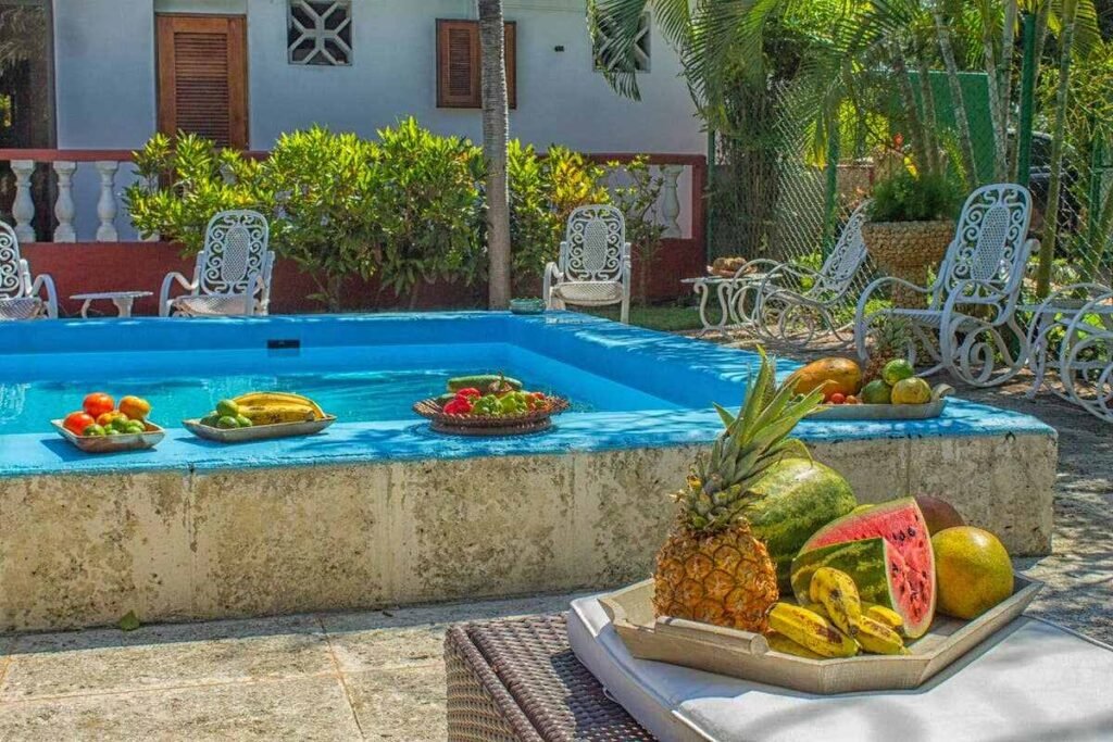 Poolside table with tropical fruit at Villa Maison