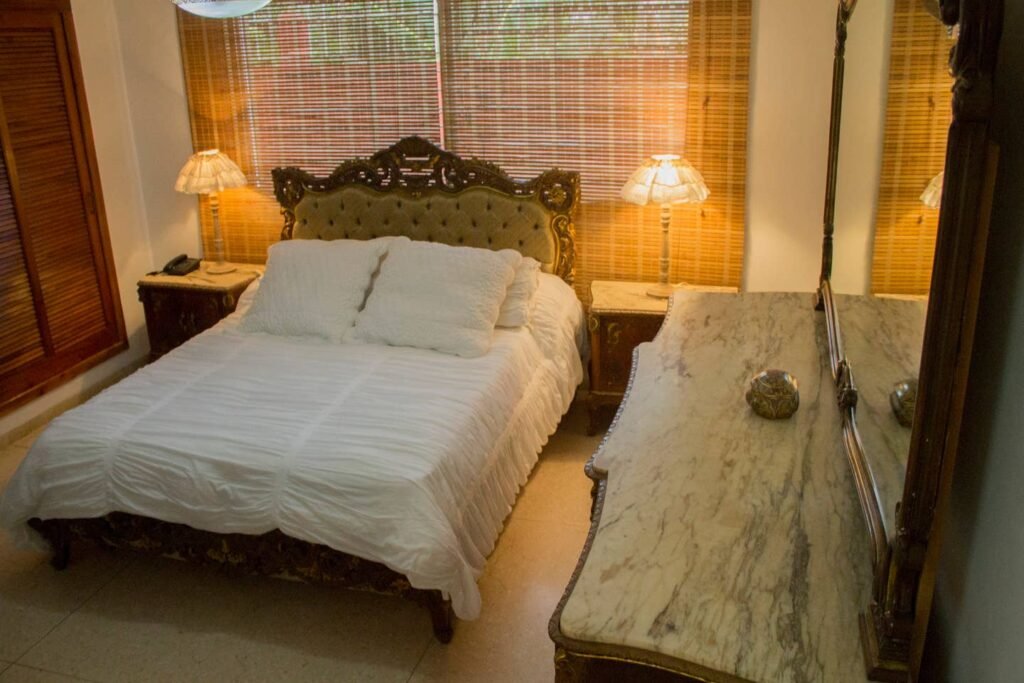 Double bedroom with carved headboard at Villa Maison