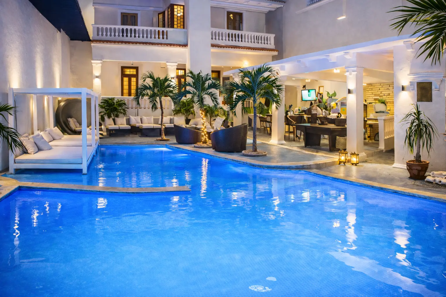 Illuminated private pool and white façade at Villa Pat in Havana