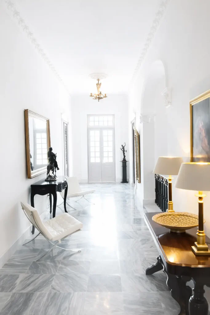 White entrance hall and dark wood furniture at Villa Pat