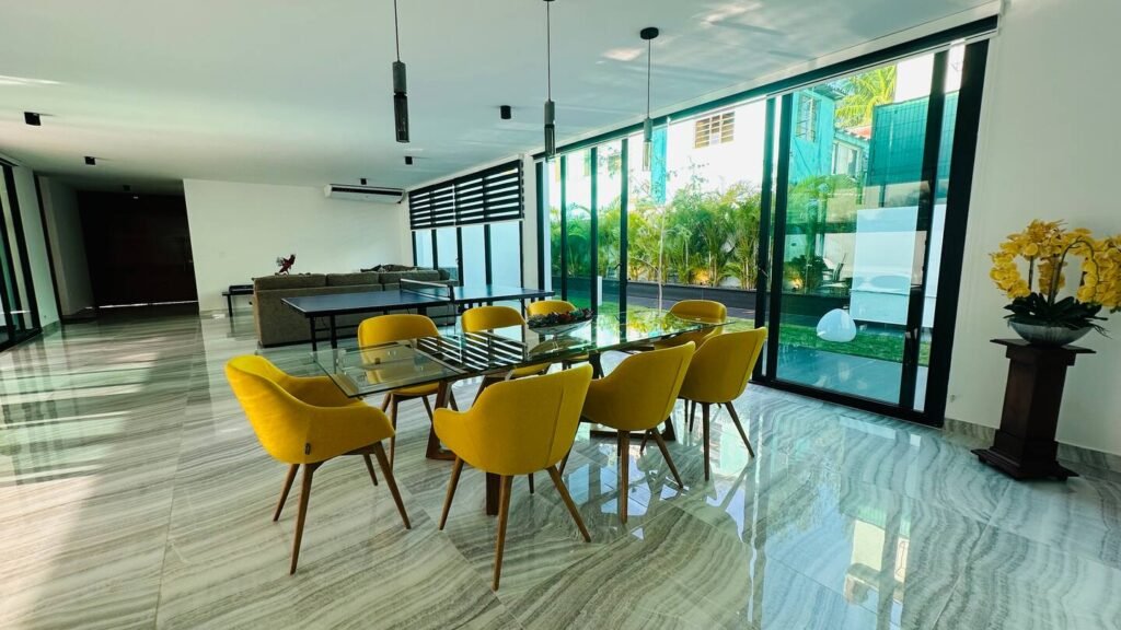 Glass dining table and garden-facing living space at Villa Venezia