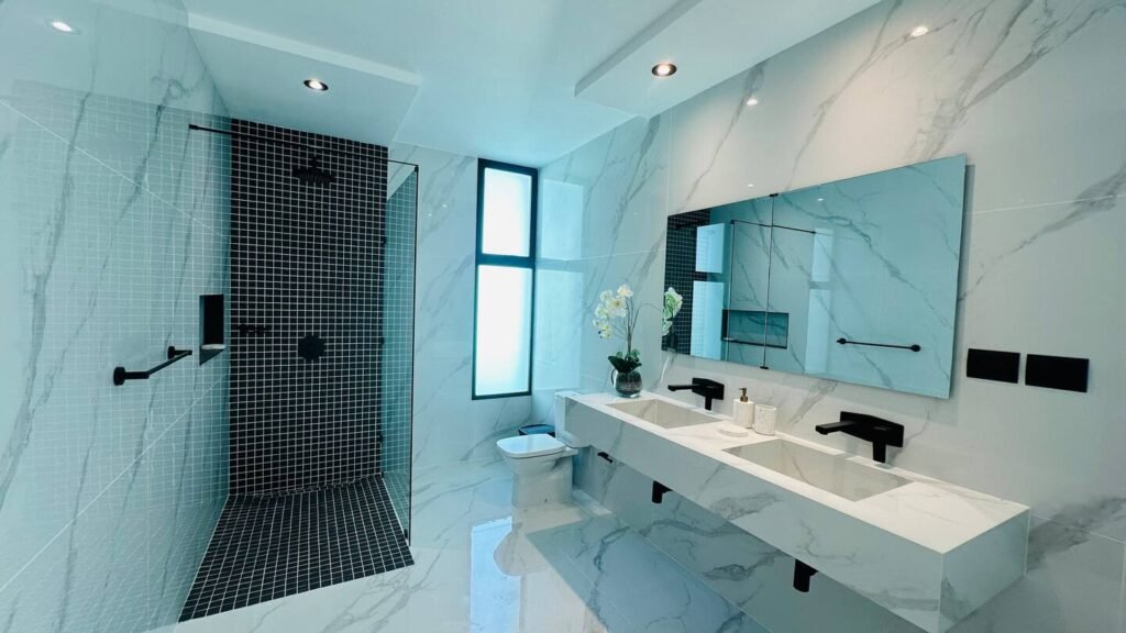 Marble bathroom with twin vanity and walk-in shower at Villa Venezia