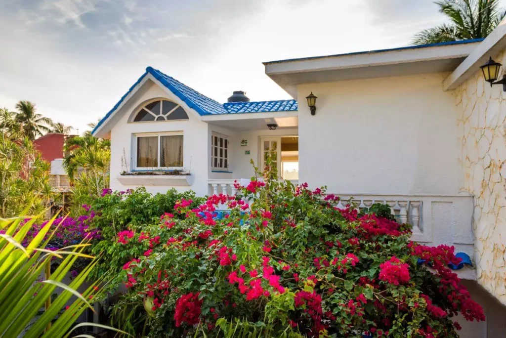 White coastal exterior and flowering garden at Villa Yan