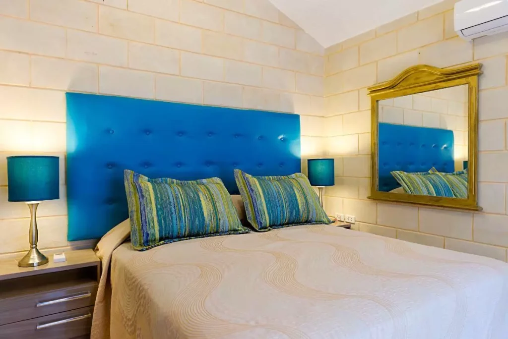 Queen bedroom with blue upholstered headboard at Villa Yan