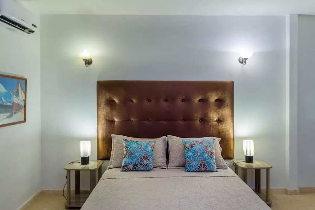 Queen bedroom with dark upholstered headboard at Villa Yan