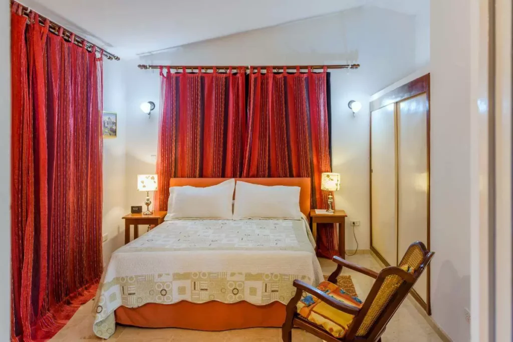 Queen bedroom with red curtains at Villa Yan